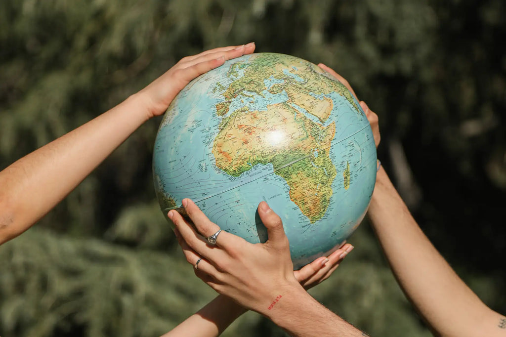 Two people holding up a globe in nature