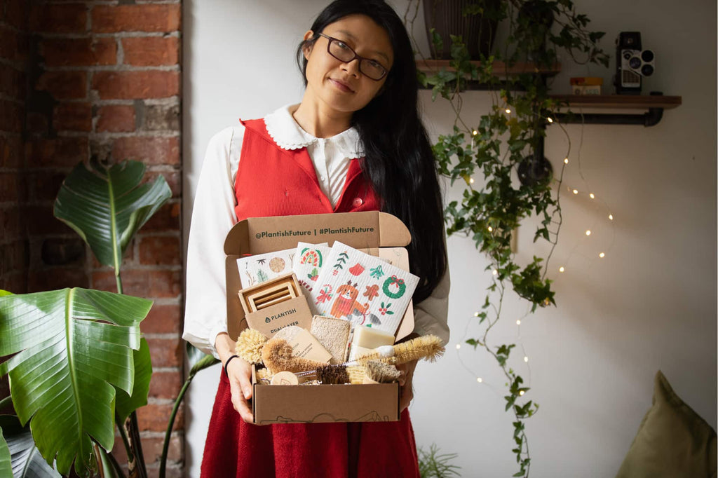 Lydia holding a box full of sustainable products, including festive sponge cloths