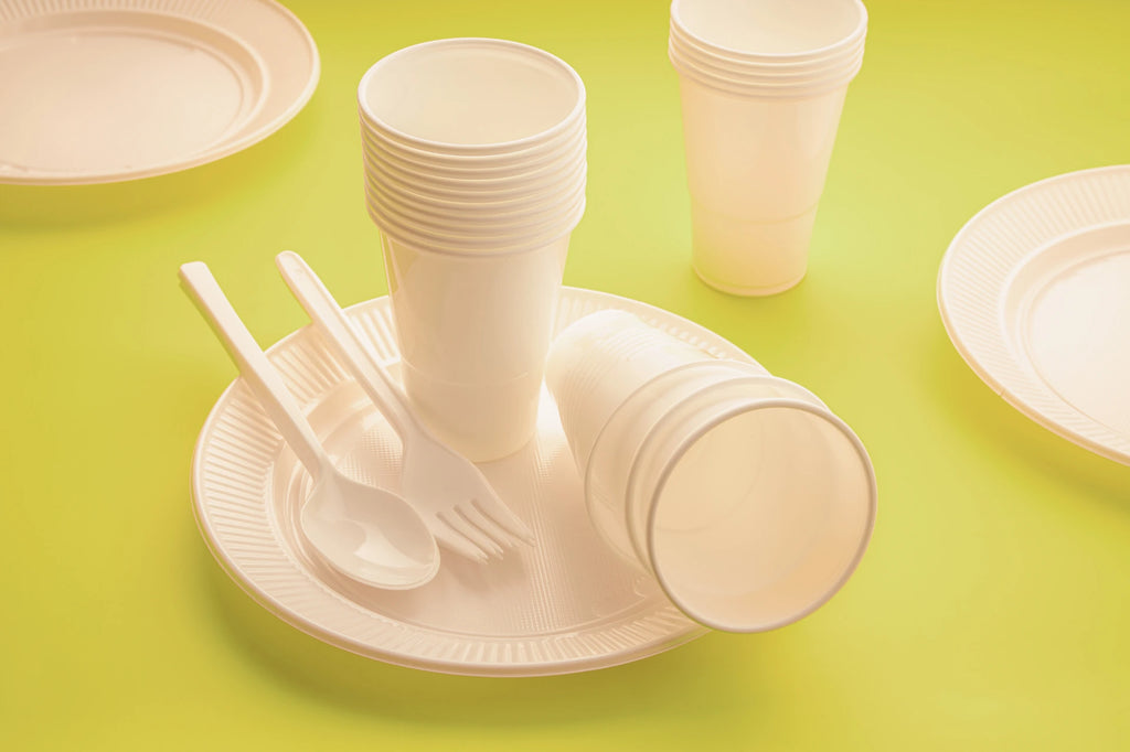 Plastic utensils, cups and plates on a table