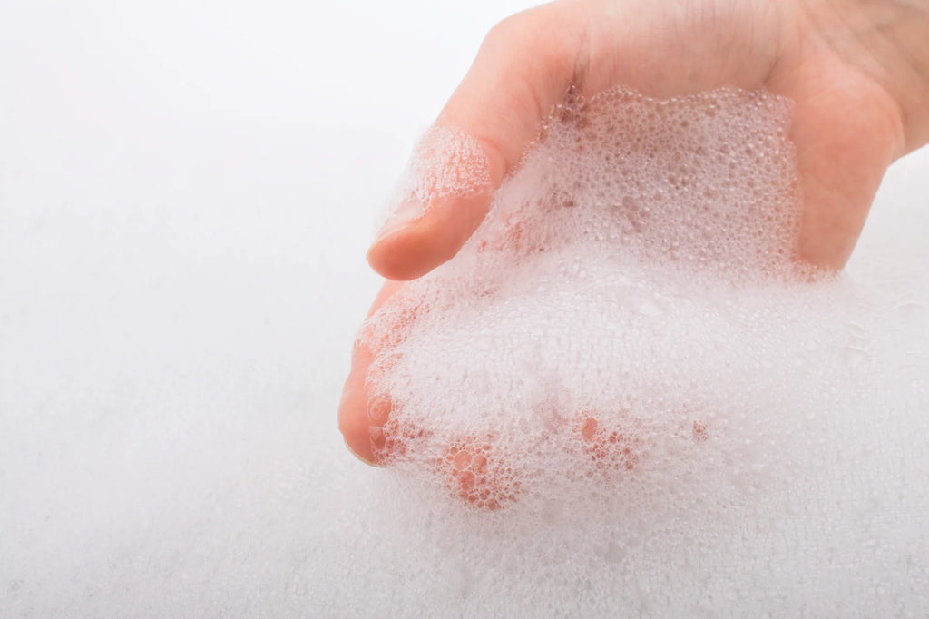 Person holding foam in the shower