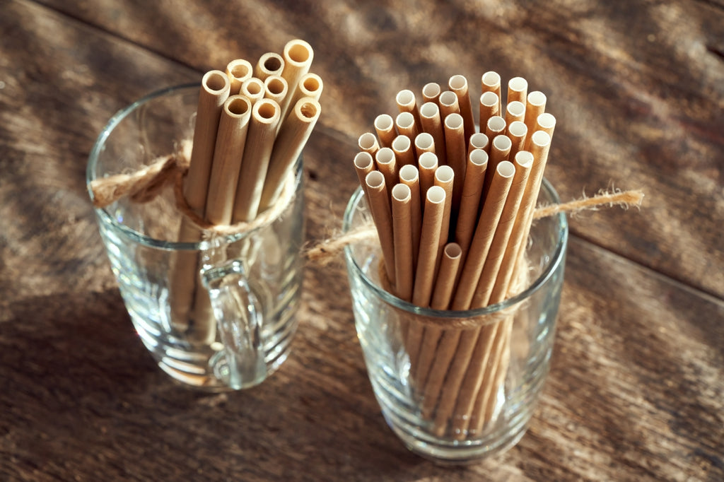 Bamboo and paper straws in glass cups