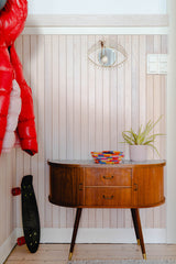 Midcentury entryway console with wall paneling and accessories