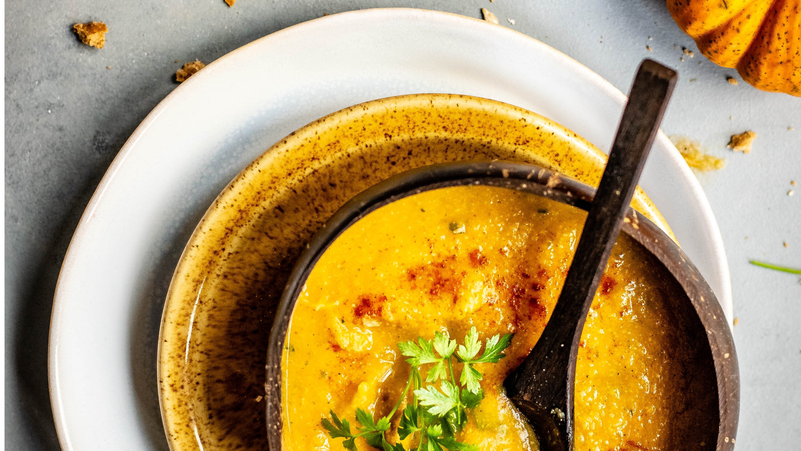 A bowl of soup and a pumpkin