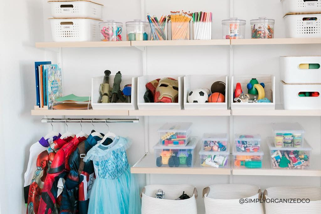 A child's closet, nicely organized with clear bins and shelves