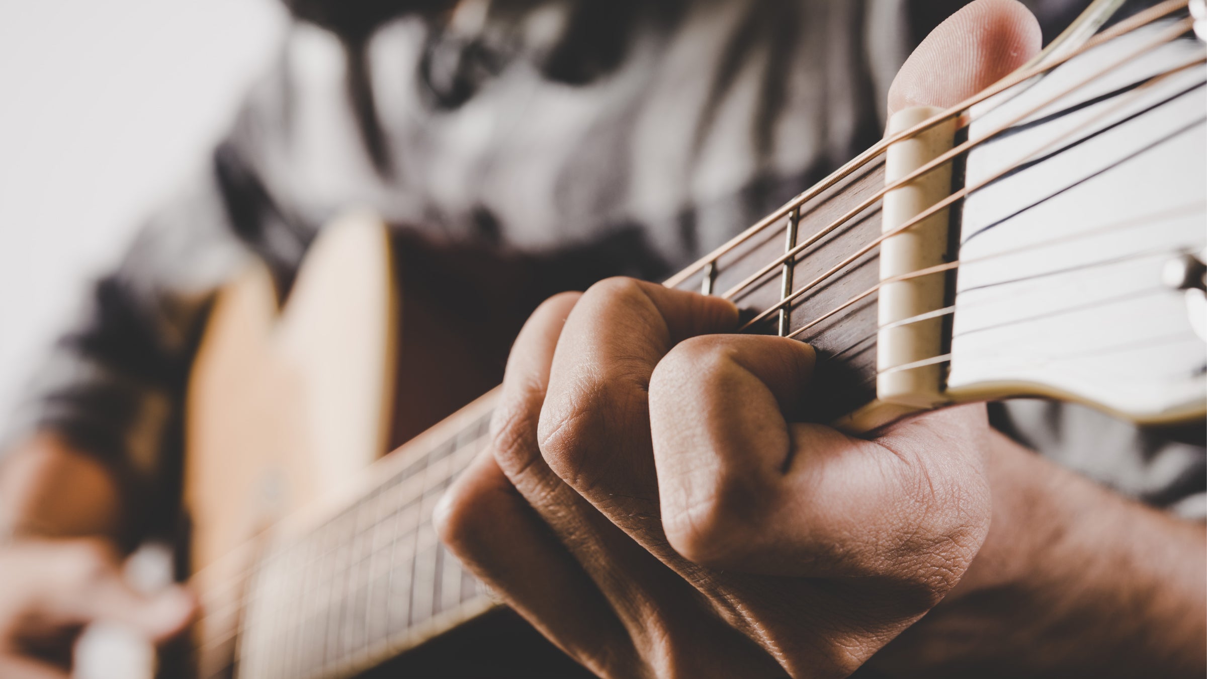A close up of a person playing a guitar