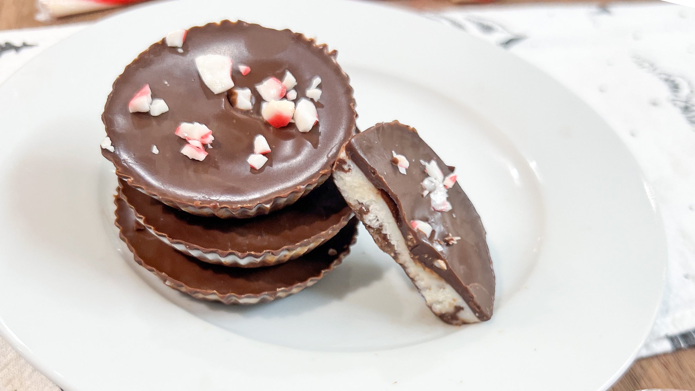 A stack of four chocolate peppermint patties on a white dish