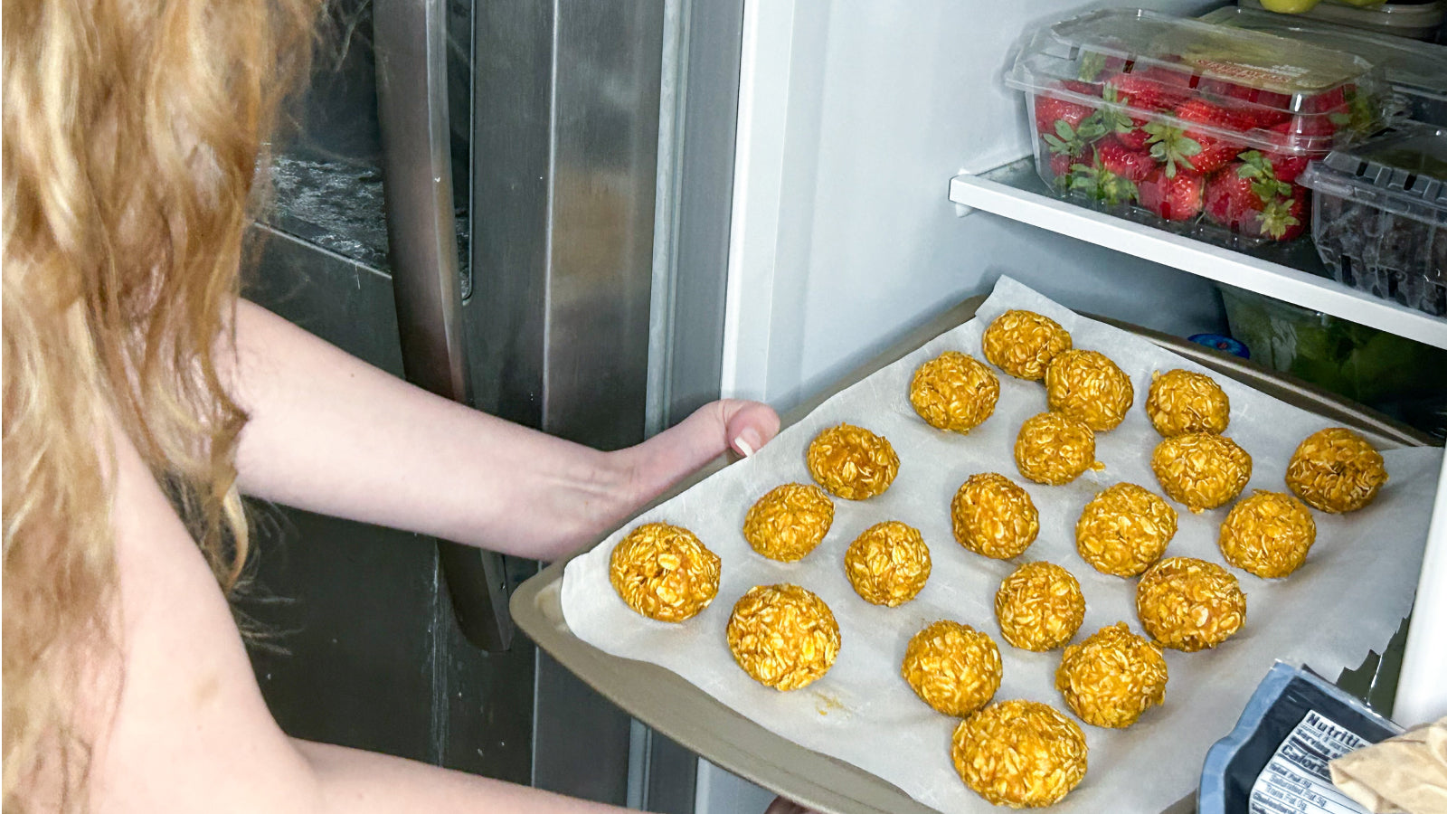 A woman with blonde hair placing no bake pumpkin dog treat balls into the refrigerator