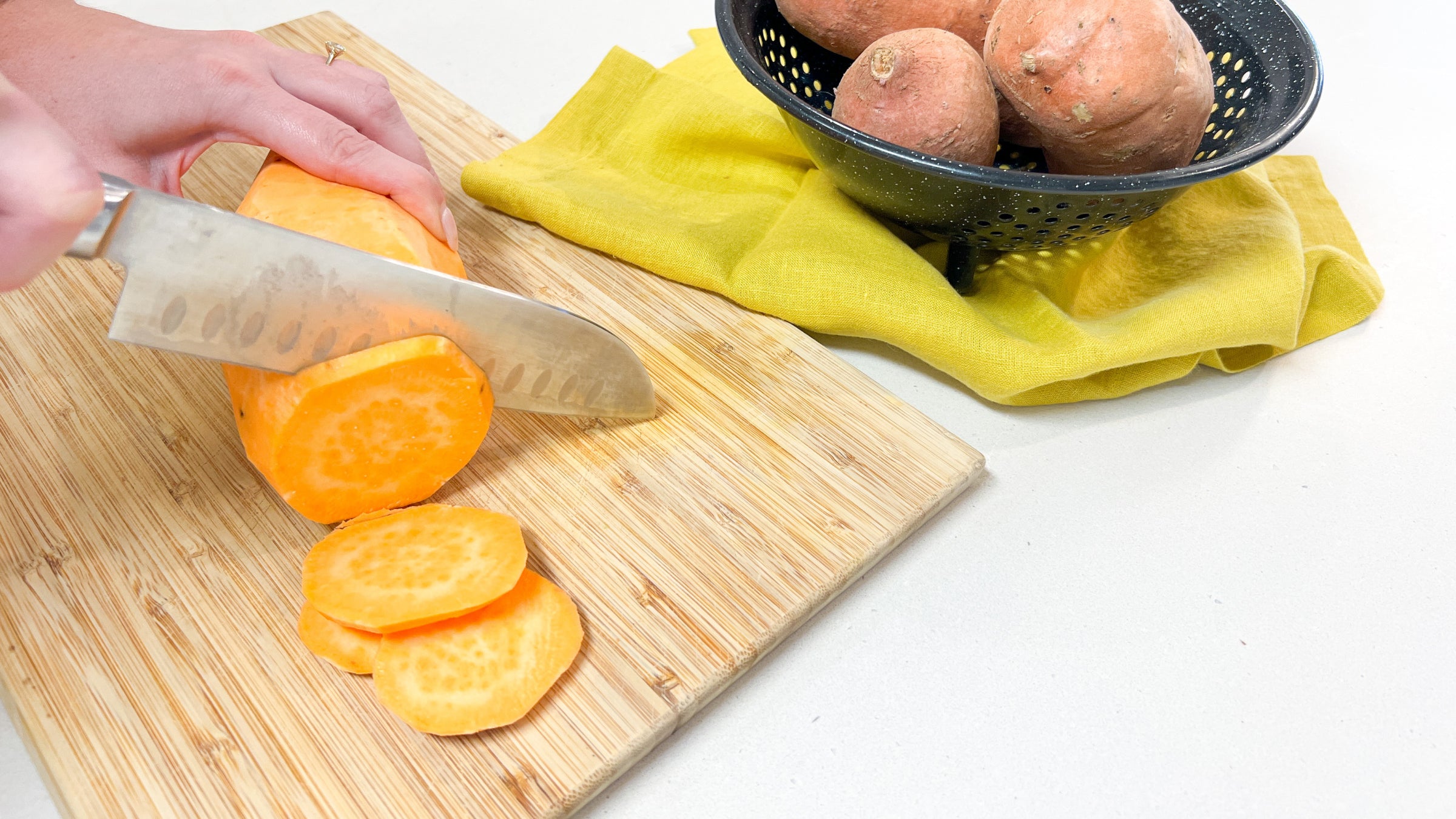 Cutting sweet potatoes on a cutting board