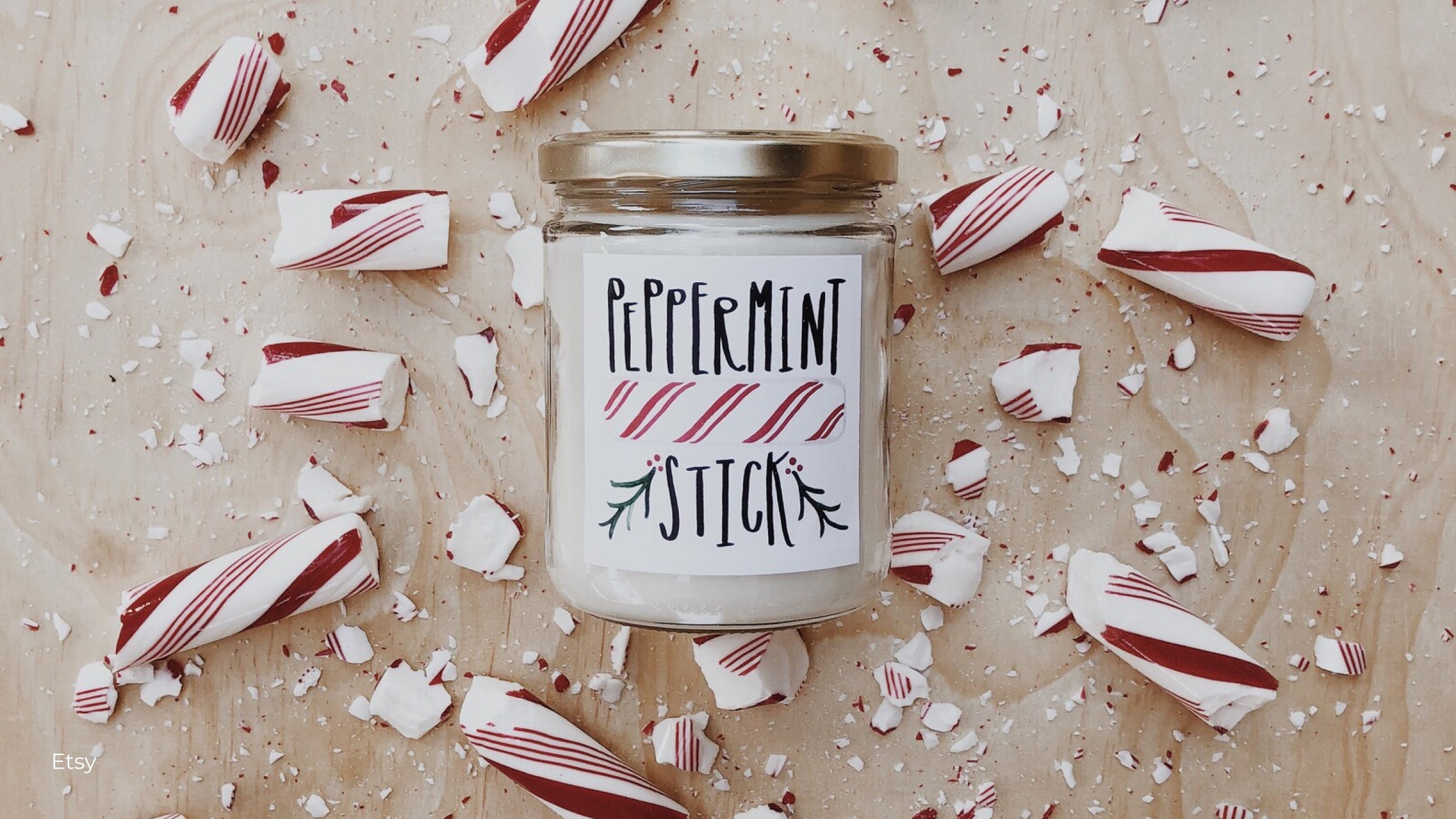 Peppermint candle from Etsy with pieces of peppermint candy broken surrounding the jar