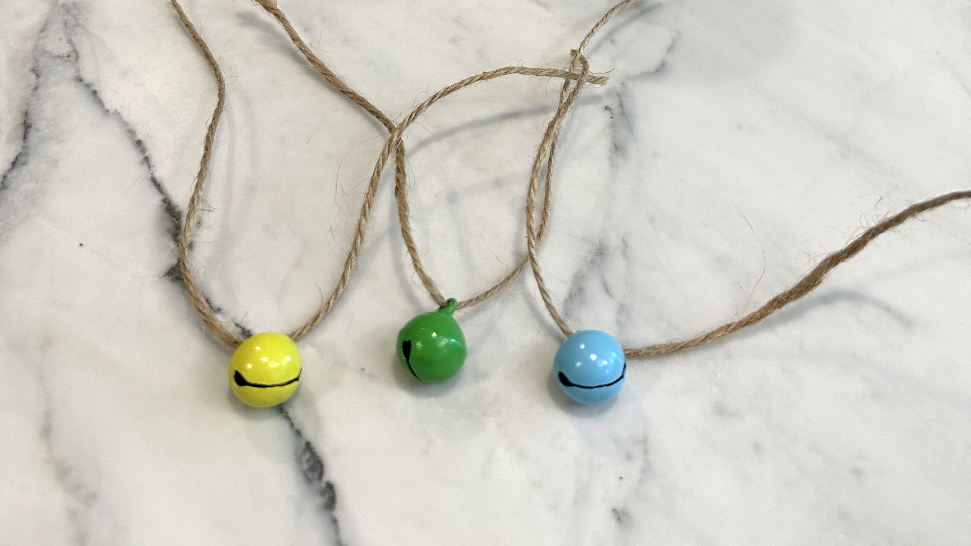 Three small colorful bells with twine