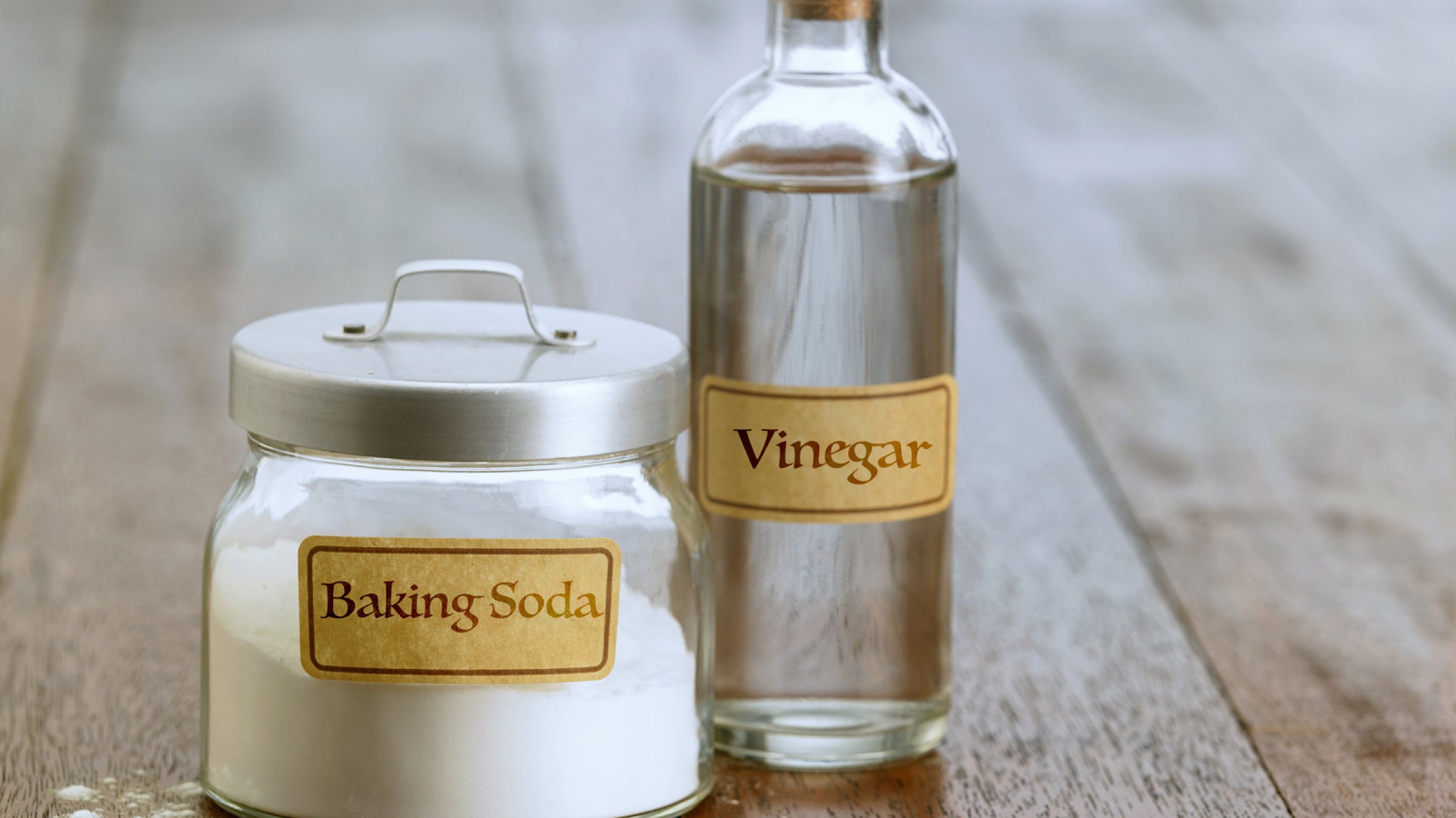 Two glass jars with labels for baking soda and vinegar