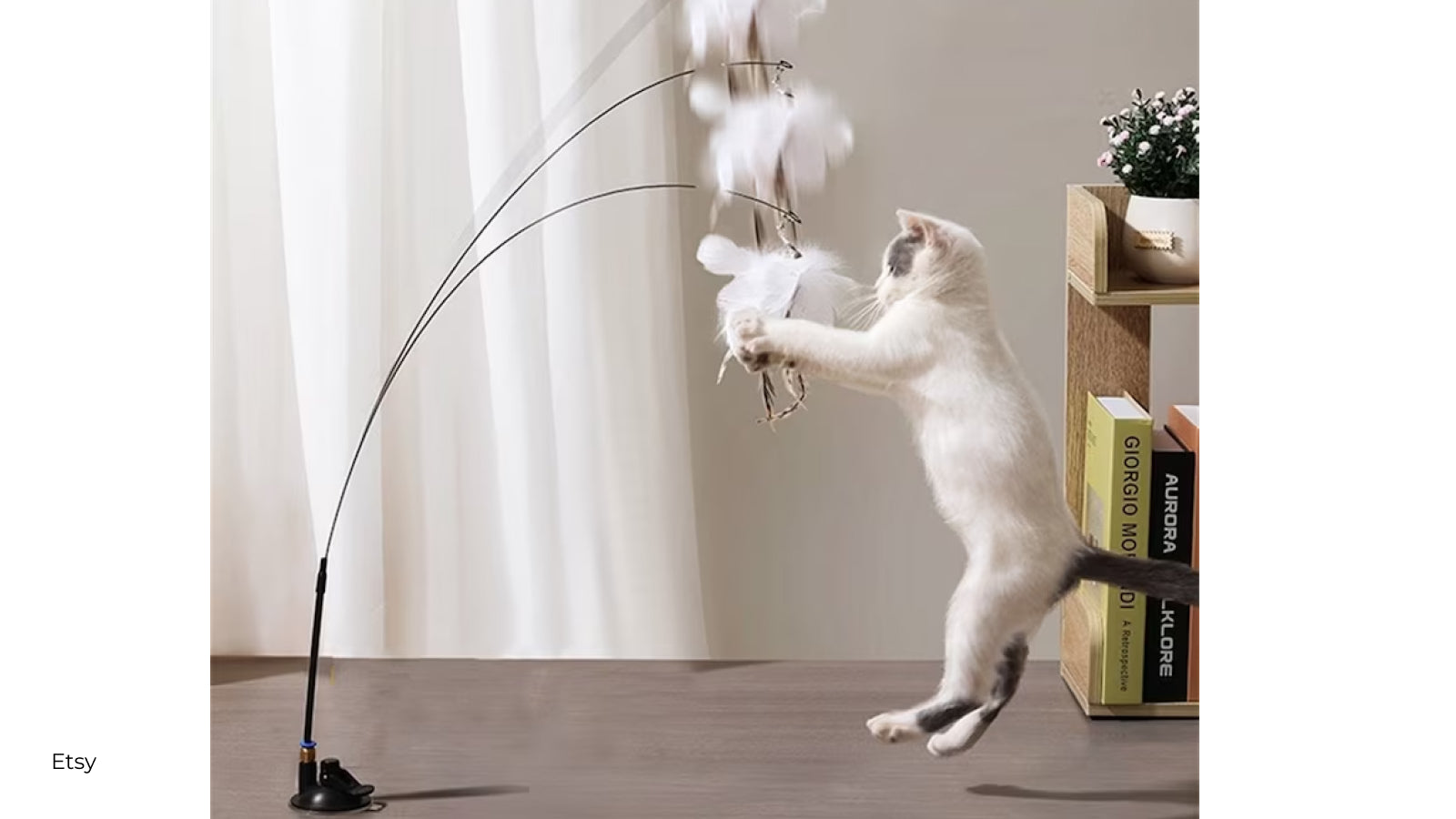 White cat playing with an interactive wand toy