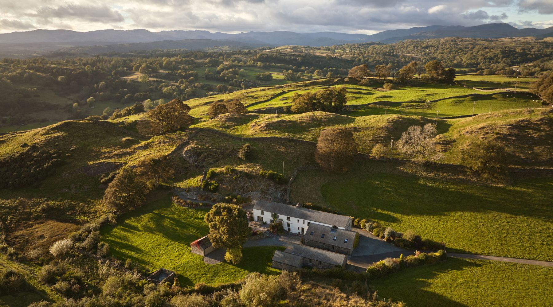Omaze Million Pound House Lake District - Ariel shot of the cottage surrounded by green hilly fields