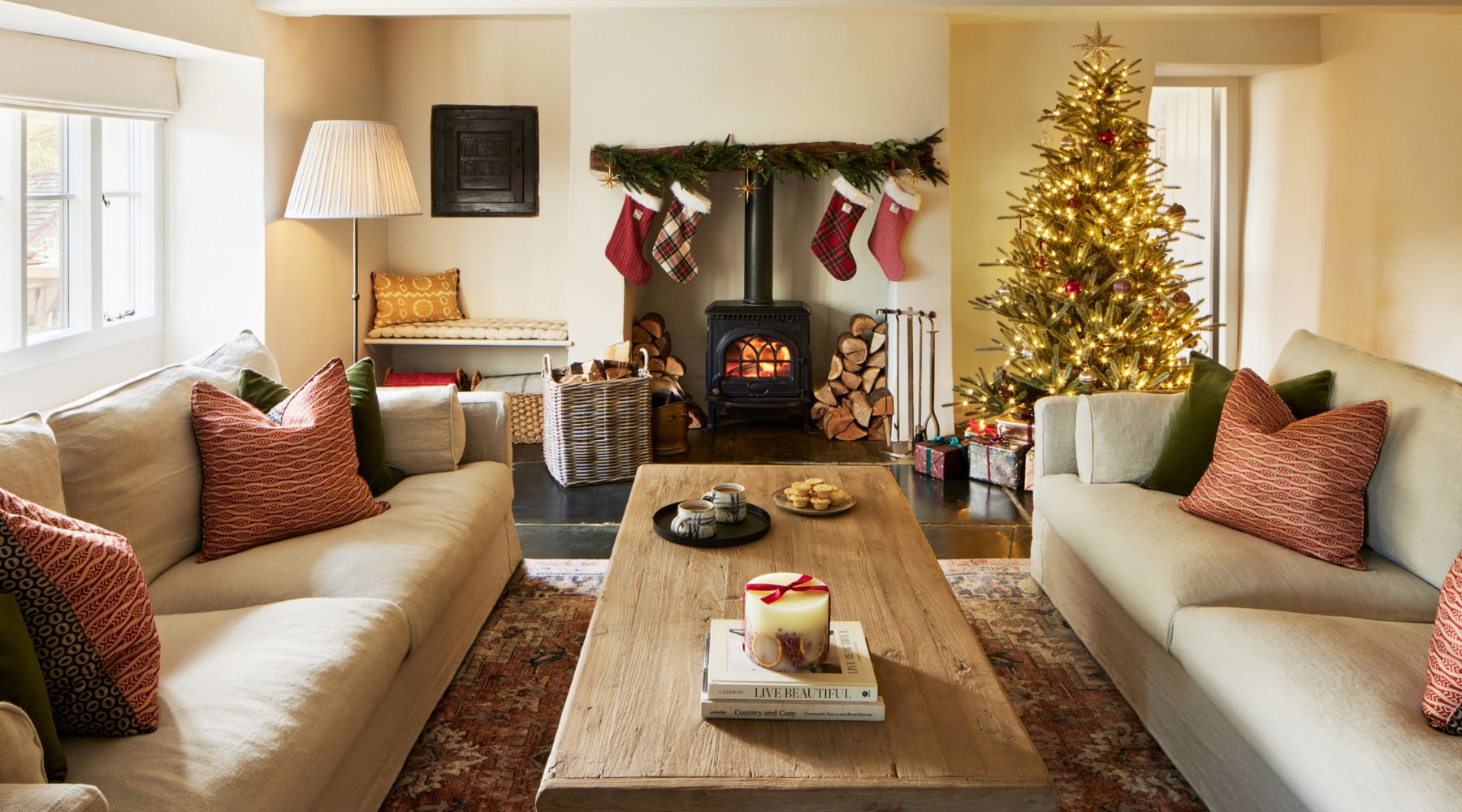 Omaze Million Pound House Lake District Cosy Lounge with log burner and Christmas tree and Christmas stockings hung around the fire