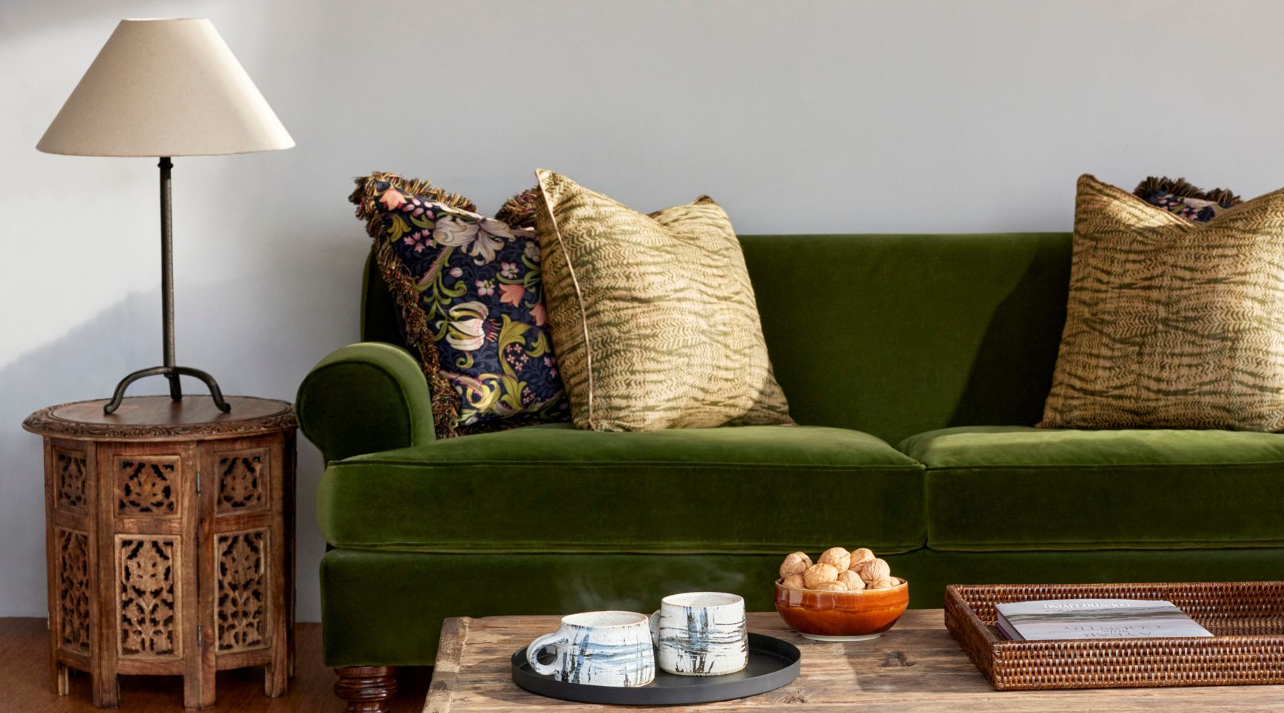 Omaze Million Pound House Lake District - green velvet sofa with botanical cushions in sun room