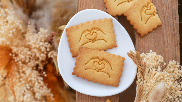 Biscuits d'anniversaire de mariage avec des mains formant un cœur