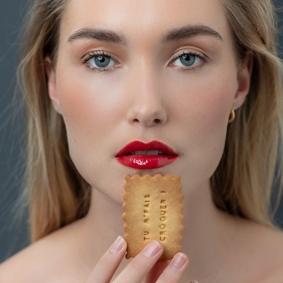 Femme portant à sa bouche un biscuit à message d'amour