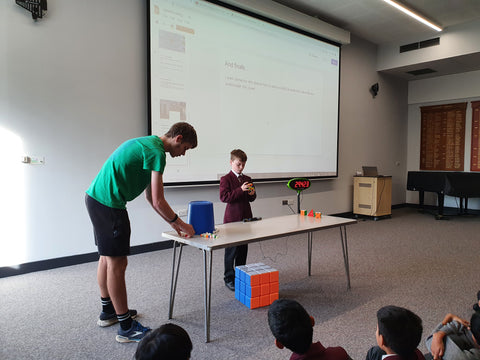 kid solving a 3x3x3 cube in front of his peers in school assembly