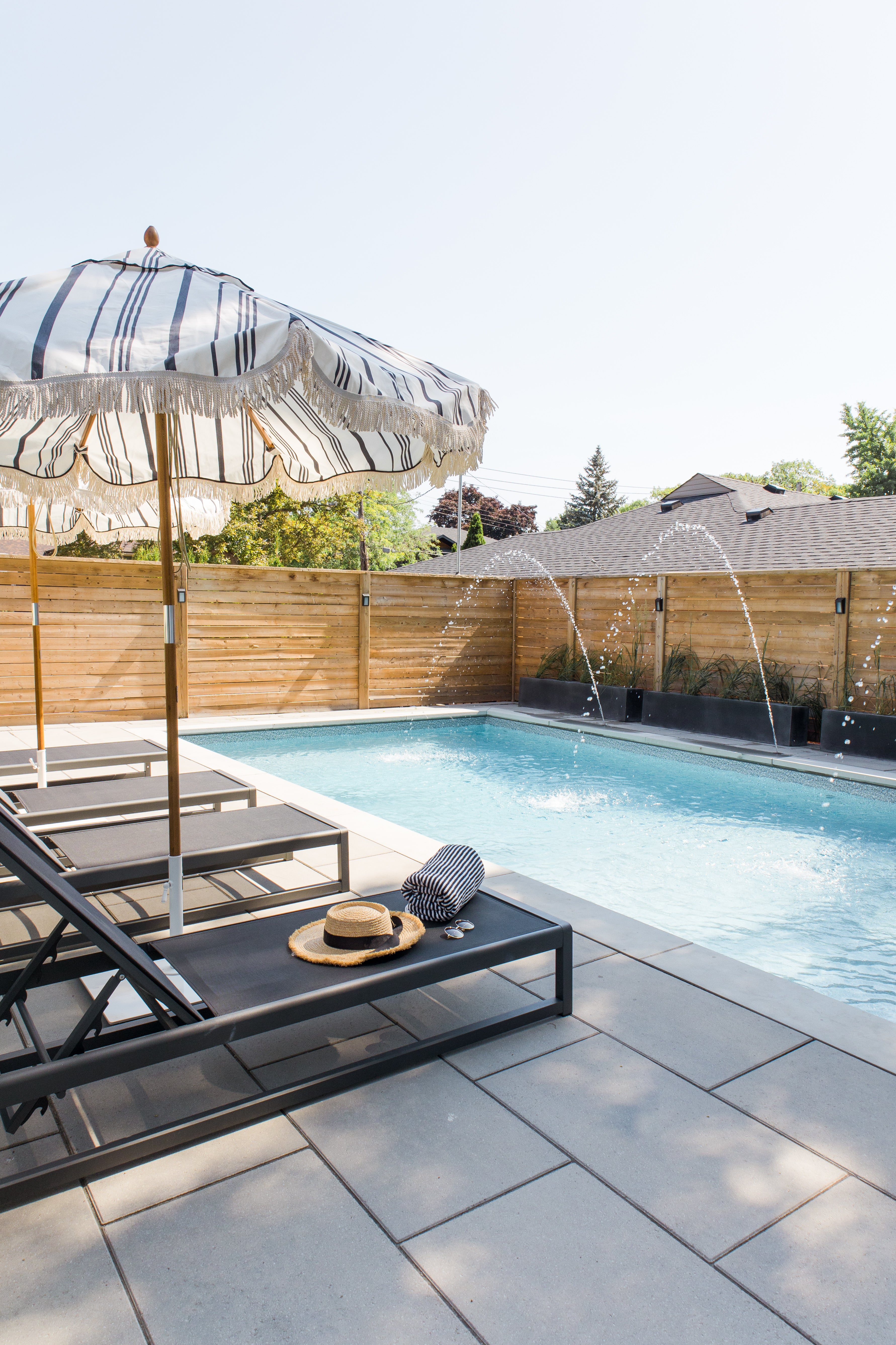 black pool loungers and umbrellas by pool 