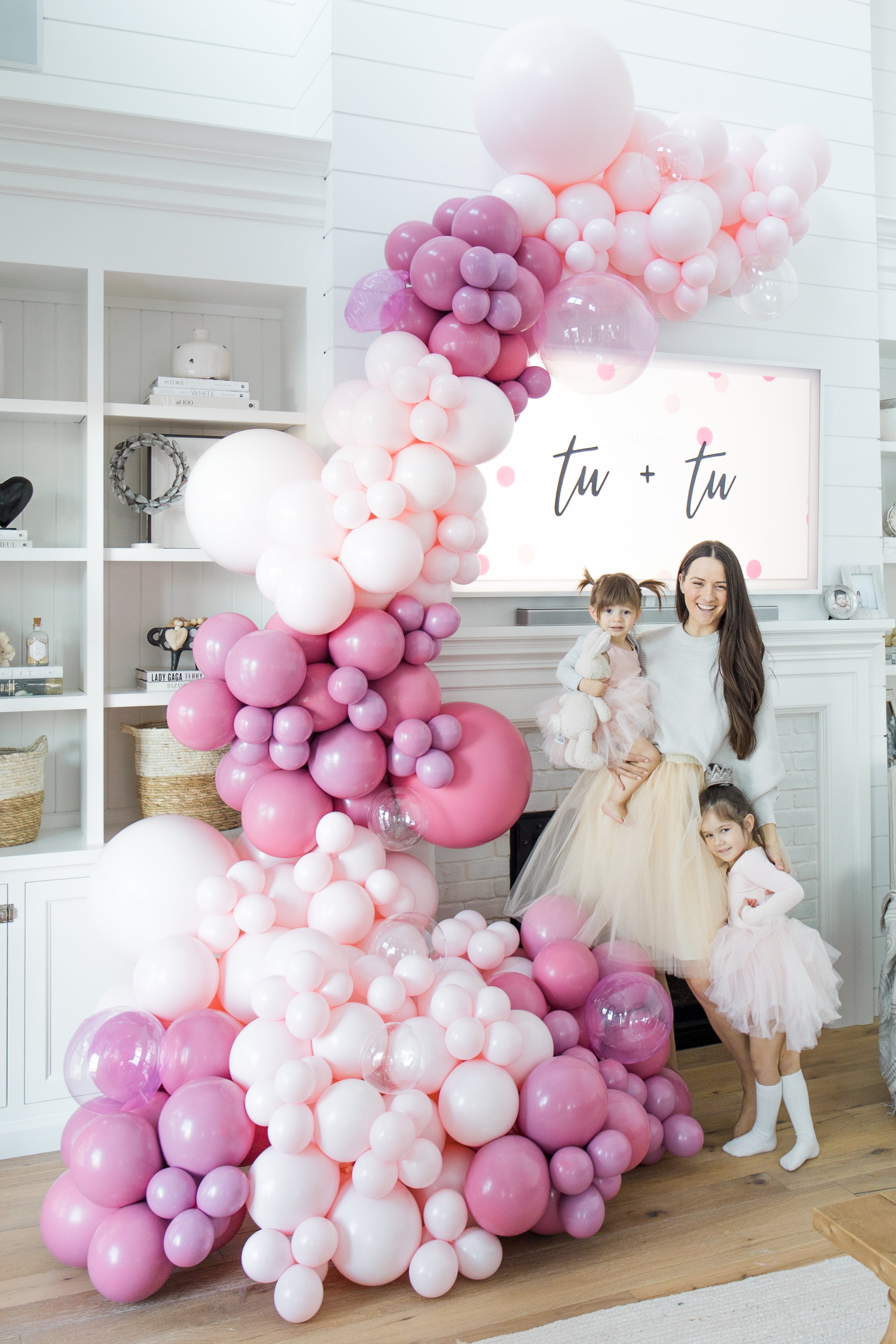 mom and daughters standing infant of balloon display