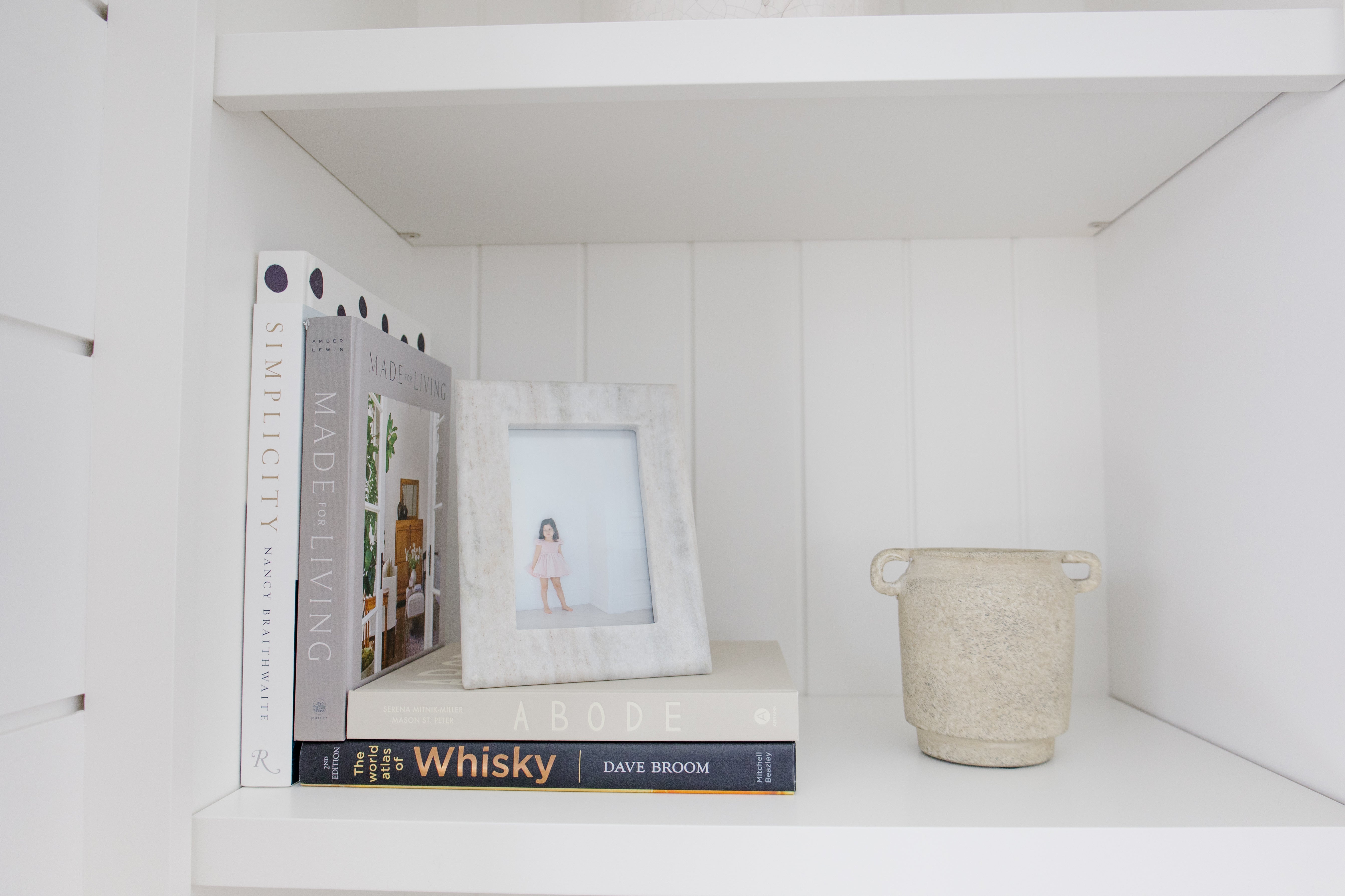 books displayed with frame and vase