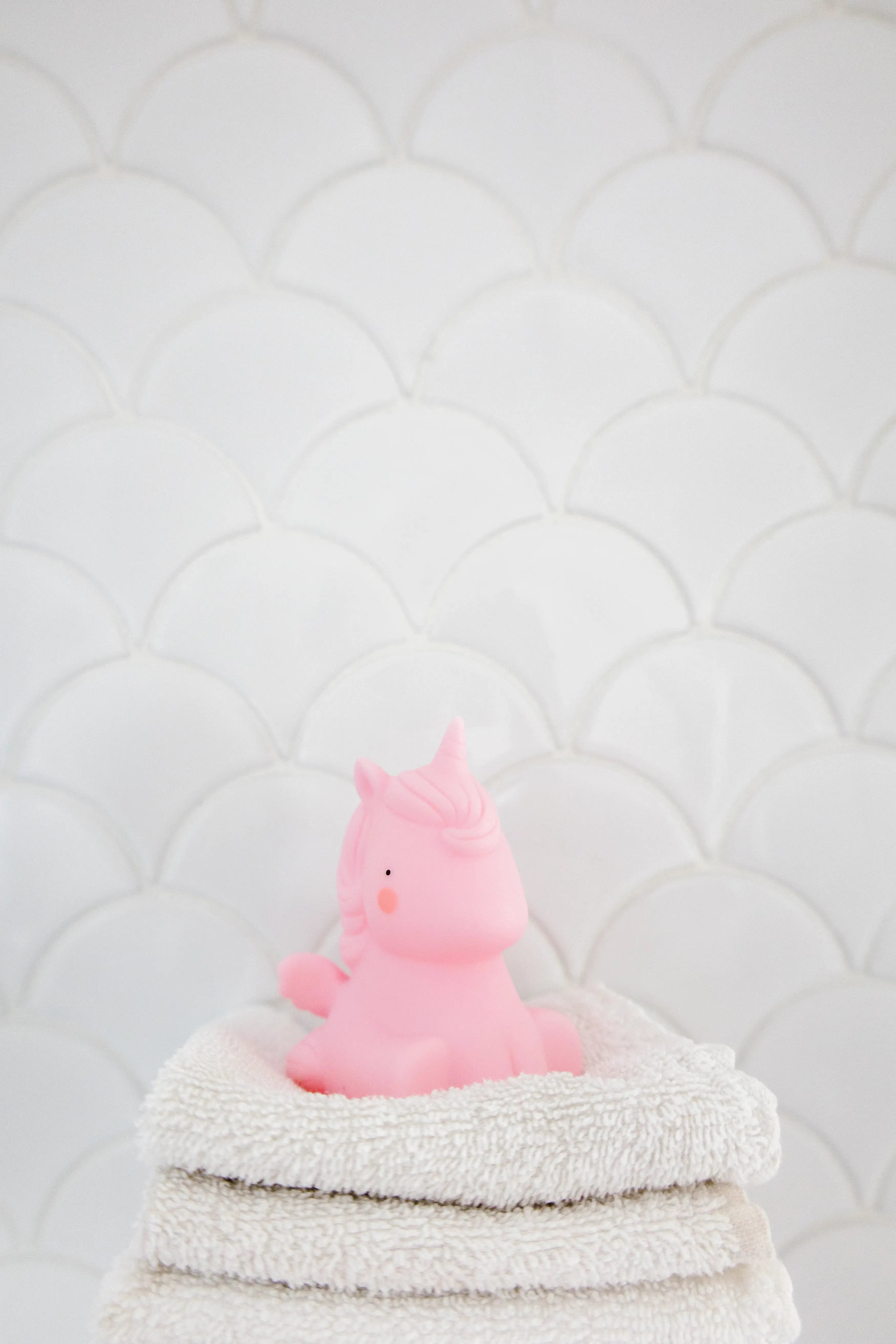 unicorn bath toy sitting on towels