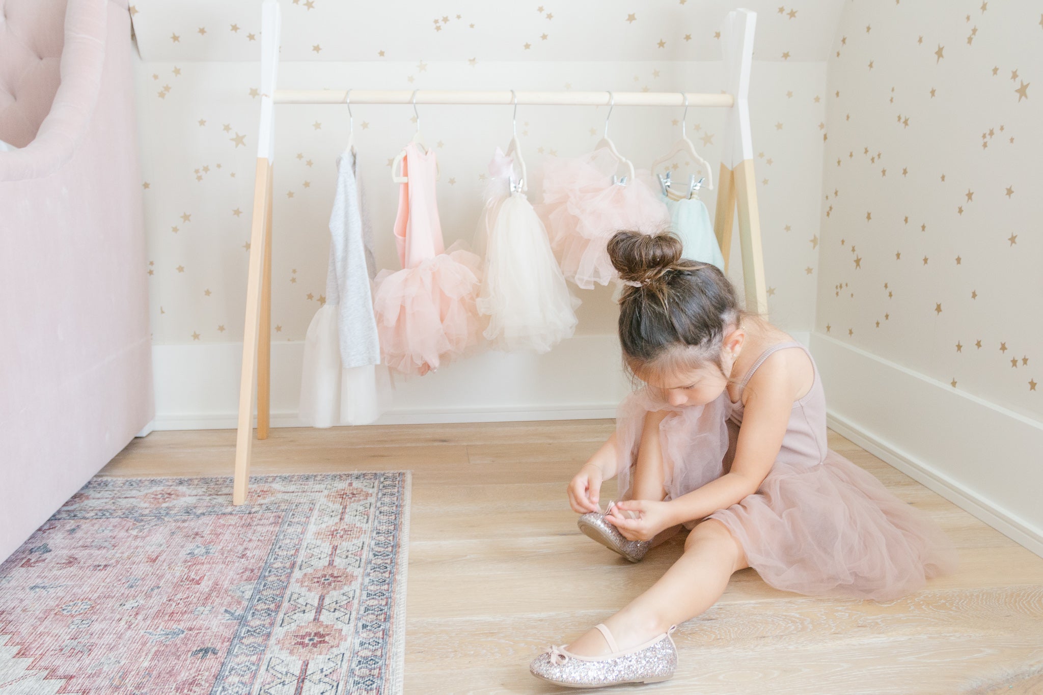 little girl putting on sparkly shoes