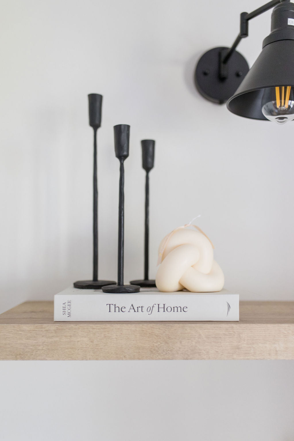 candlesticks, knot pillar candle and a book