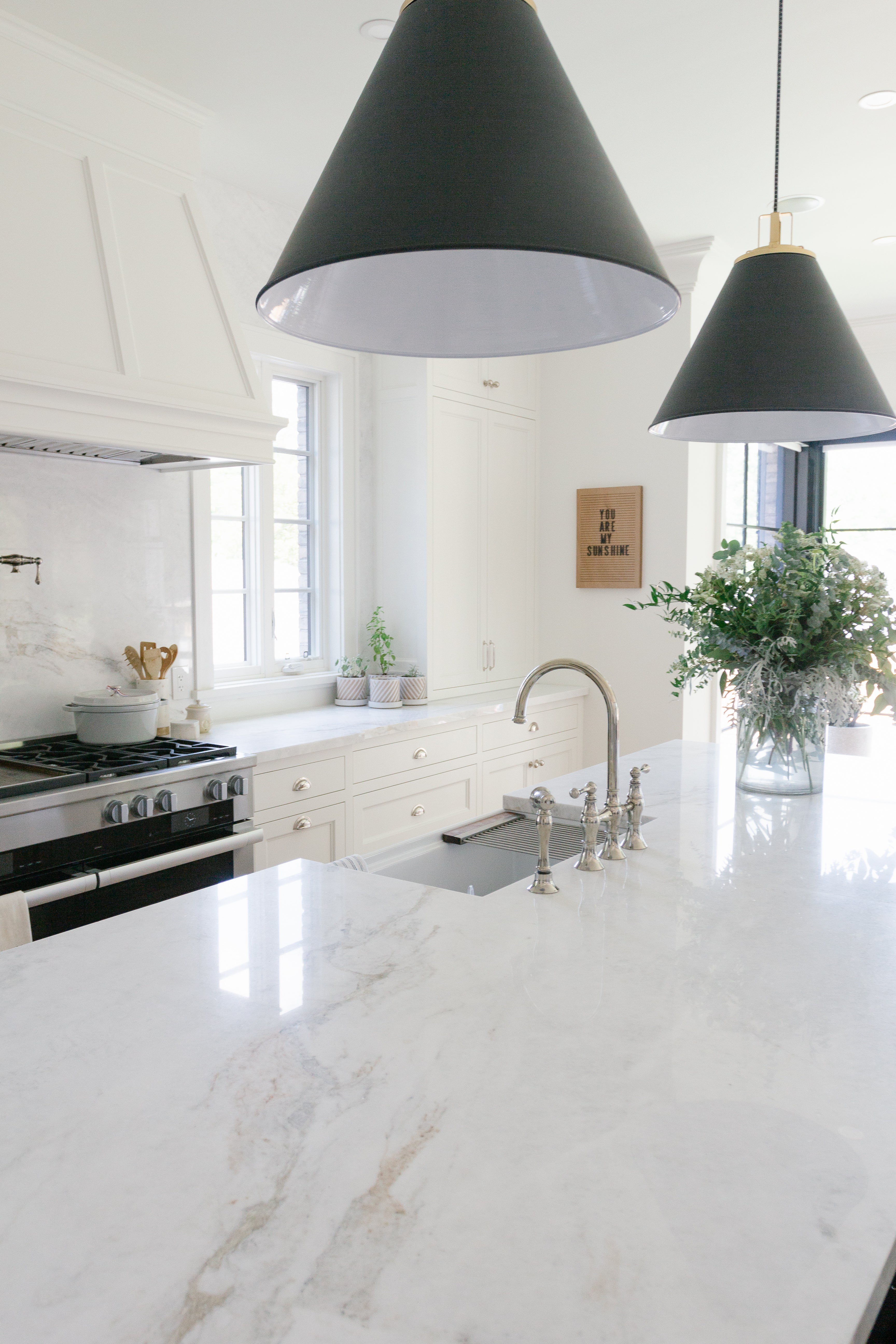 White kitchen, black pendants and oriental white quartz countertop