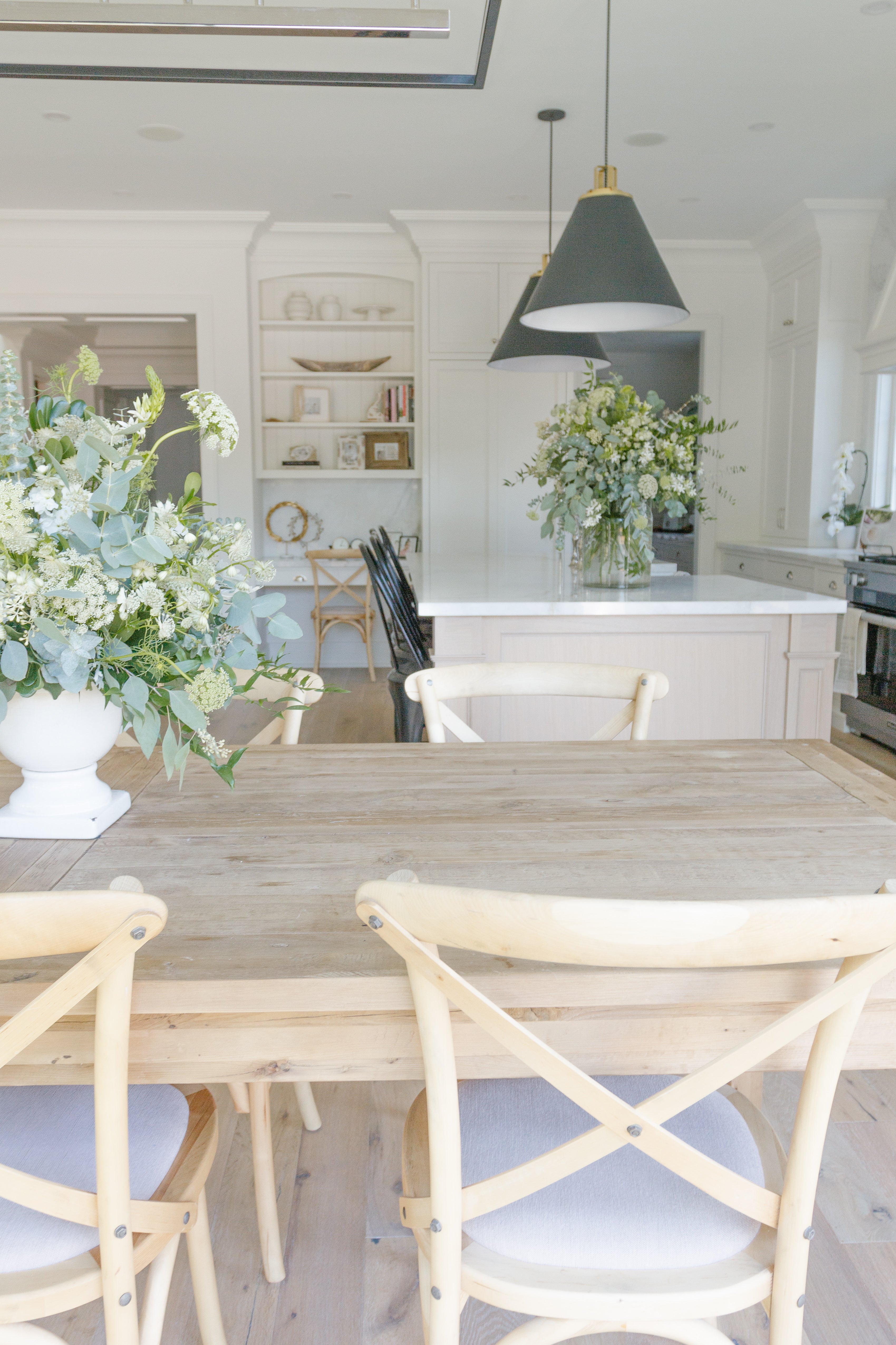 wood table and chairs in a white kitchen