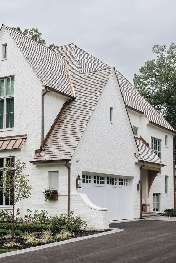 white home with side garage and cedar roof