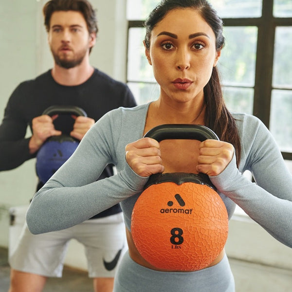 Man and woman using kettle weights