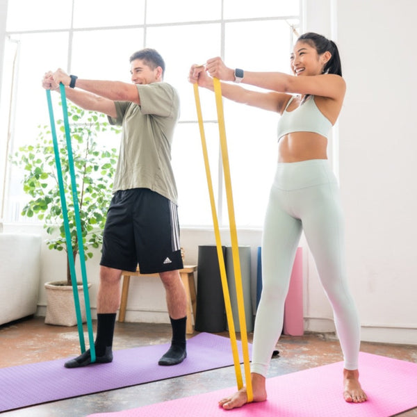 Man and woman using resistance bands