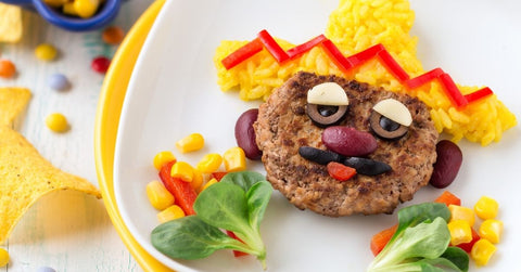 Beef burger, potato and vegetable Mexican face and sombrero scene