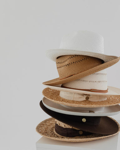 Different Two Roads men’s hats for smaller heads stacked atop one another