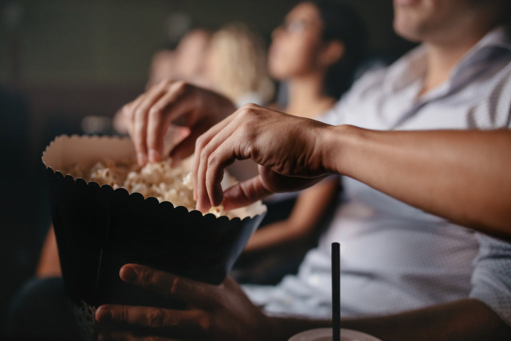 Young people eating popcorn at the movies