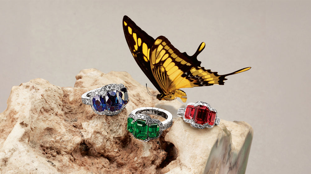 Picchiotti ring trilogy featuring sapphire, emerald, and ruby. Butterfly over top.