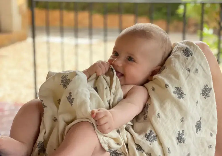 Ein Baby nimmt ein Pucktuch in den Mund