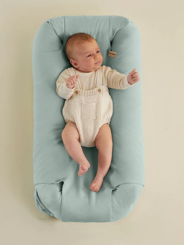 Baby liegt auf einem loulouby Babynest in Ocean Blue