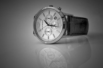 Beautiful mens watch with reflection on marble featuring black leather strap silver dial chronograph