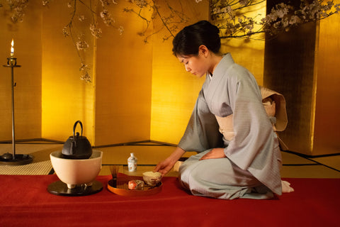 woman sitting inside room doing tea ceremony