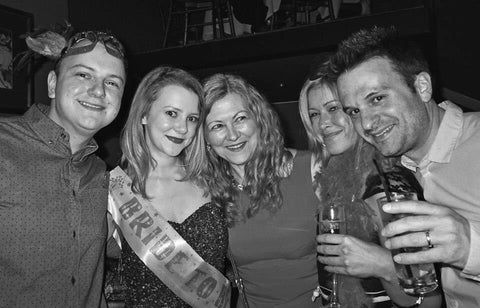 Black and white photo of a family posing for a photo at a hen party 