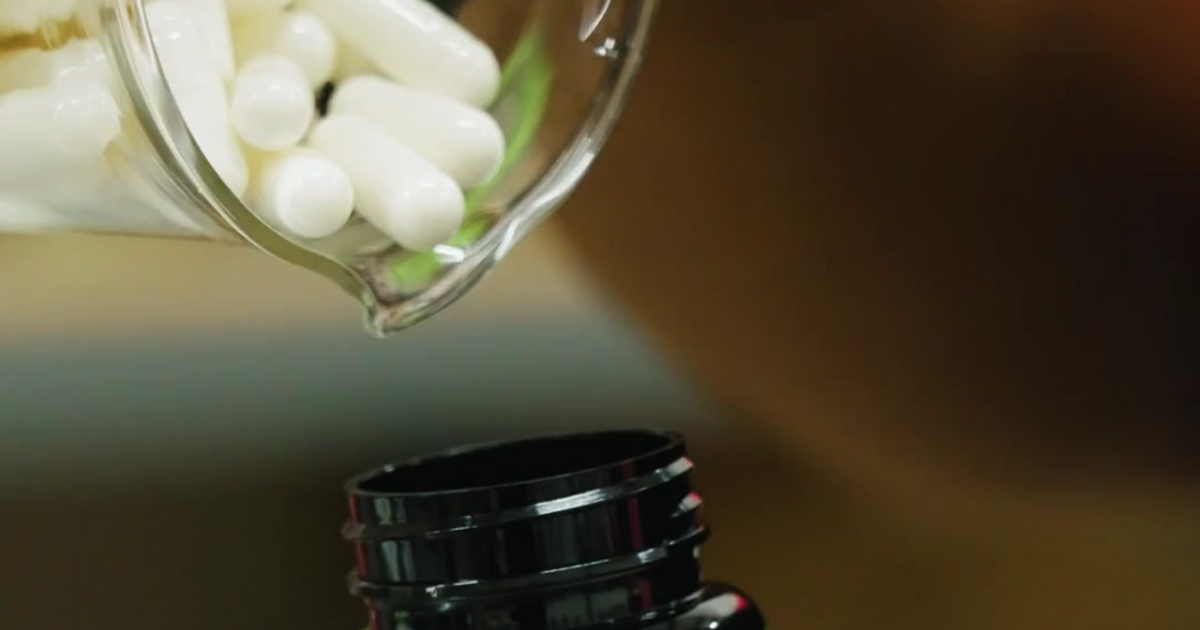 A jar filled with boric acid suppositories by Goddess of the Sea being poured into another bottle.