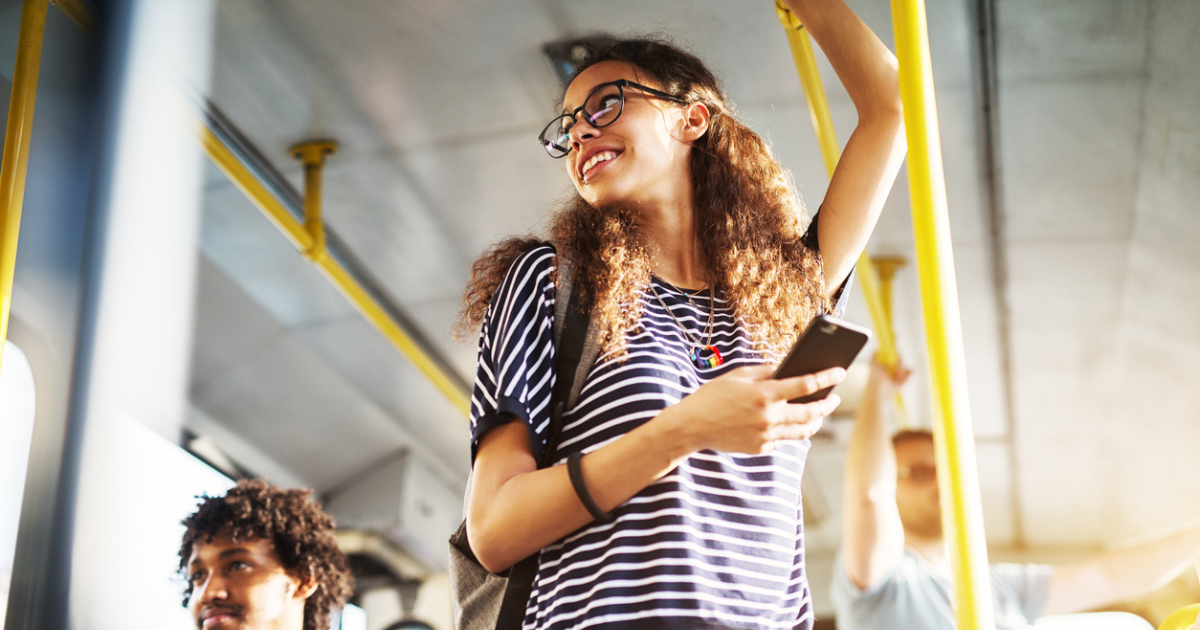 A smiling woman with beautiful skin on the bus.