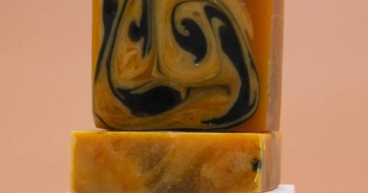 Image of Goddess of the Sea Tumeric and Charcoal Bar Soap on a peach brown background.