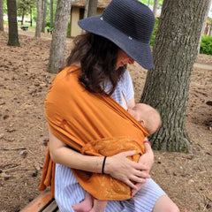 Babywearing makes breastfeeding easier by supporting your baby against you.