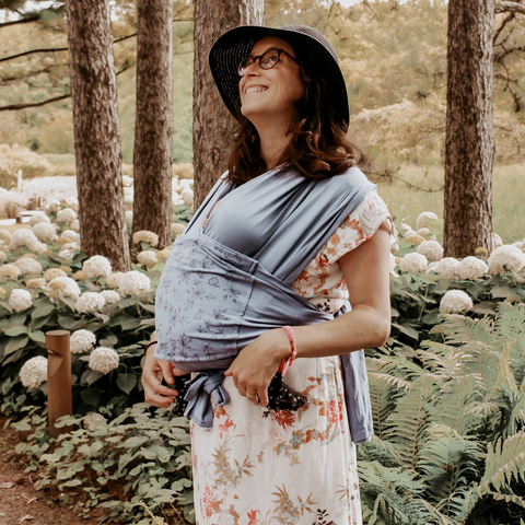 Une maman qui porte l’écharpe polyvalente Snug.