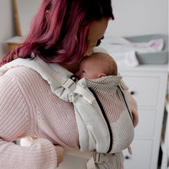 Un nouveau-né en porte-bébé polyvalent EvöAir bblüv.
