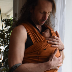 A dad filled with happiness at the sight of his baby in a Snüg.