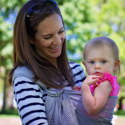 A mom carrying her daughter in her Ring Sling